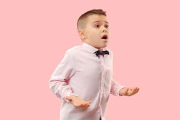 Wow. Attractive male half-length front portrait on pink studio backgroud. Young emotional surprised teen boy standing with open mouth. Human emotions, facial expression concept. Trendy colors