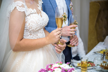 Bride and groom at the wedding table. holding a glass of champagne