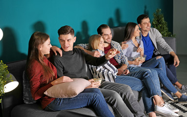 Young people watching movie in home cinema at night