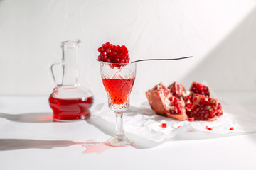 Pomegranate wine, seeds and pomegranate fruit on a light background