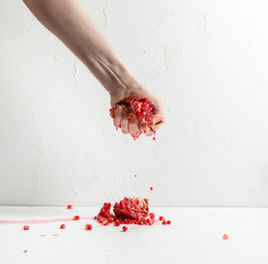 hand squeezes fruit pomegranate juice