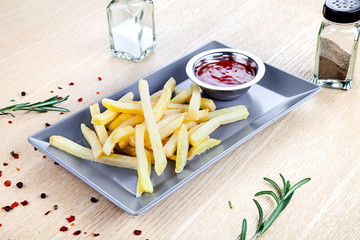 Close up view on served French fries with ketchup on white table. Beer snack. Restaurant, food...