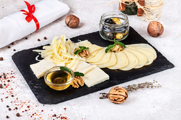 Close up view on traditional Georgian served assorted cheeses with honey and nuts. Georgian food. Restaurant, food menu, recipe, cafe concept. Lifestyle with copy space