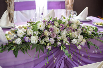 Wedding. Banquet. The chairs and round table for guests, served with cutlery, flowers and crockery and covered with a tablecloth