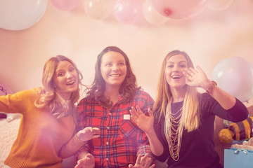 Pregnant woman celebrating baby shower party with friends.