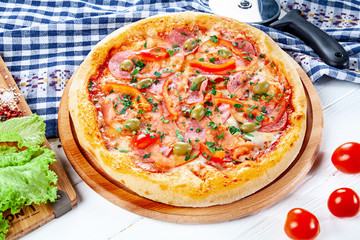 Close up view on pizza on white wooden background with ingridients. Italian cuisine. Ready to Eat. Restaurant, food menu, recipe, cafe concept. Lifestyle with copy space