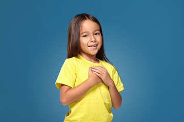 little girl in yellow t-shirt hands on her heart