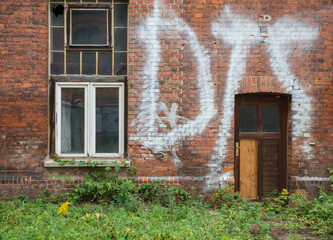 Fototapeta na wymiar Old window in an old brick wall on the autumn orange yellow tree