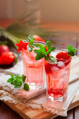 Sparkling pink strawberry lemonade on dark wooden background