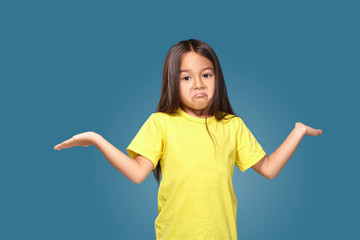 Surprised girl with spread arms on blue background