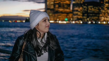 Fototapeta na wymiar Young woman enjoys the fantastic view over the Manhattan skyline by night