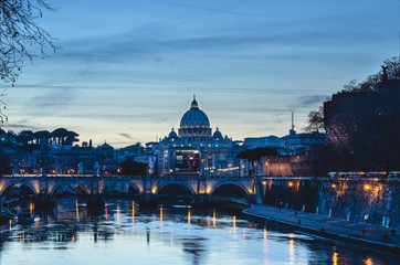 Obraz na płótnie Canvas A sunset view of St Peters basilica with the Tiber river