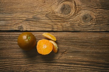 Dark orange isolated on wooden background. Brown oranges.