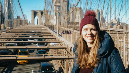 Young beautiful woman relaxes on Brooklyn Bridge while enjoying the amazing view