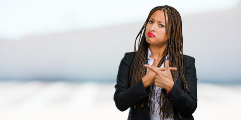 Portrait of a young black business woman confused and doubtful man, decide between two options,...