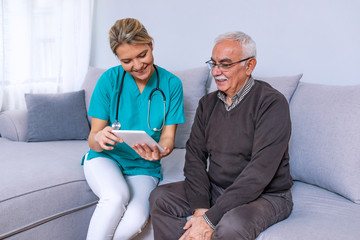 Young nurse spending time with happy elder patient in nursing home