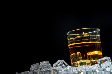 Whisky or whiskey or bourbon with ice on ice background.