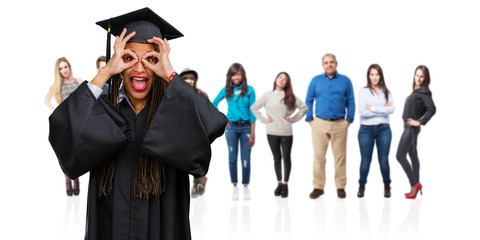 Young graduated black woman wearing braids cheerful and confident doing ok gesture, excited and screaming, concept of approval and success