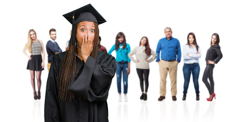 Young graduated black woman wearing braids very scared and afraid, desperate for something, cries of suffering and open eyes, concept of madness