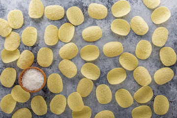 Potato chips on grey concrete table. Concept of fast food and snacks.