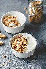 Breakfast bowls with organic granola, nuts, coconut chips and greek yoghurt.