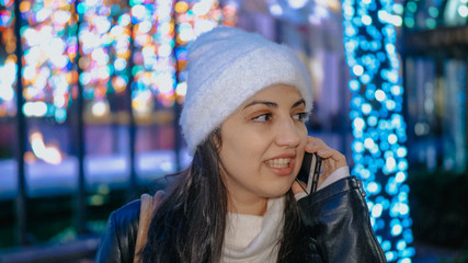 Young woman enjoys the beautiful Christmas decoration in the city