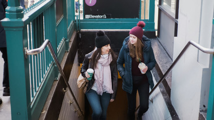 Two young women at a New York subway station