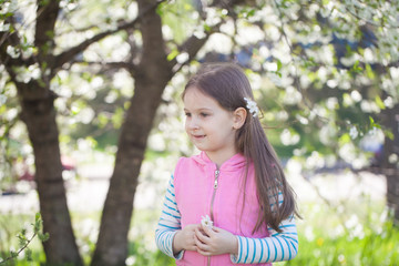 Cute girl in a blooming cherry tree garden