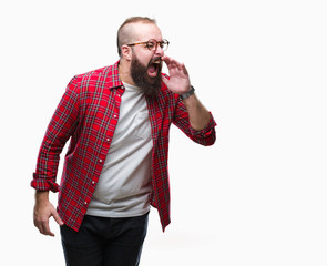 Young caucasian hipster man wearing glasses over isolated background shouting and screaming loud to side with hand on mouth. Communication concept.