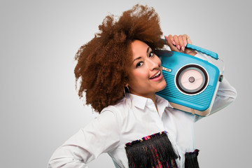 young afro woman holding a vintage radio