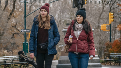 Two young woman on a trip to New York take a relaxing walk in Central Park