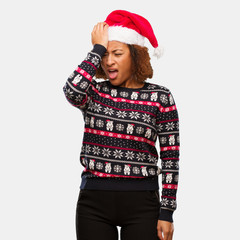 Young black woman in a trendy christmas sweater with print forgetful, realize something