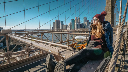 Obraz na płótnie Canvas Young beautiful woman on Brooklyn Bridge New York enjoys a wonderful sunny day