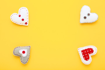 Colorful fabric hearts on yellow background