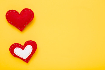 Red fabric hearts on yellow background