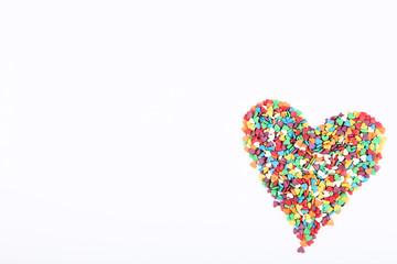 Fototapeta premium Colorful heart shaped sprinkles on white background
