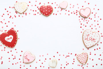 Valentine day cookies with heart shaped sprinkles on white wooden table