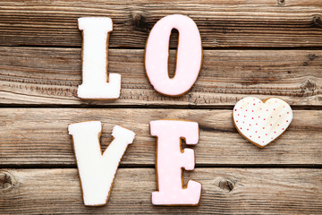 Word Love by cookies and heart on brown wooden table