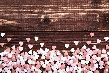 Heart shaped sprinkles on brown wooden table