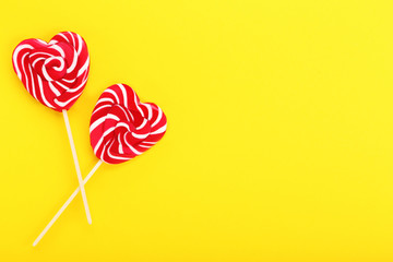 Heart shaped lollipops on yellow background