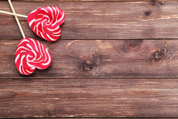Heart shaped lollipops on brown wooden table