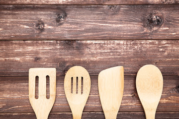 Wooden kitchen cutlery on brown table