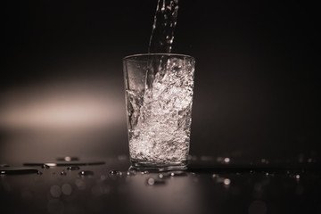 On a black background in a glass of water poured