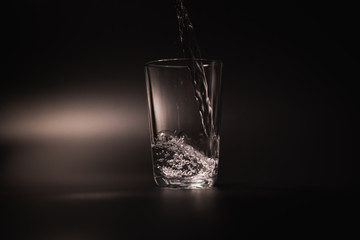 On a black background in a glass of water poured