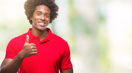 Afro american man over isolated background doing happy thumbs up gesture with hand. Approving...