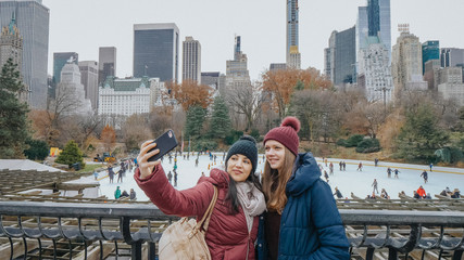 Two friends look over the ice rink at Central Park on a winters day