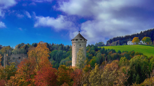 Old medieval castle tower on a hill in the forest in Europe on a bright sunny day