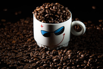 white cups with a pattern and grains of coffee on a black background