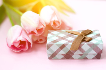 Fototapeta na wymiar Pink tulips on the pink background with gift box. Flat lay, top view. Valentines background
