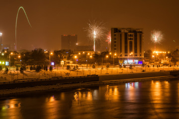 Fototapeta na wymiar panorama of fireworks in honor of the new year in Krasnodar near the river Kuban